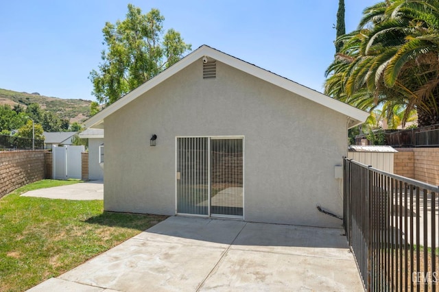 rear view of house featuring a fenced backyard, a patio, and stucco siding