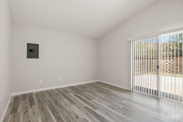 unfurnished room with lofted ceiling, baseboards, and light wood-style floors