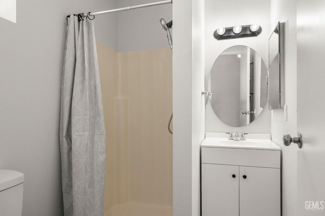 bathroom with a shower stall, toilet, and vanity