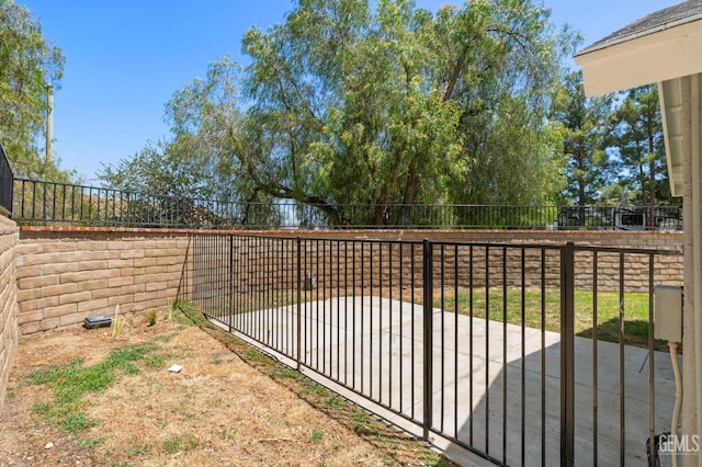 view of gate featuring a patio area and a fenced backyard