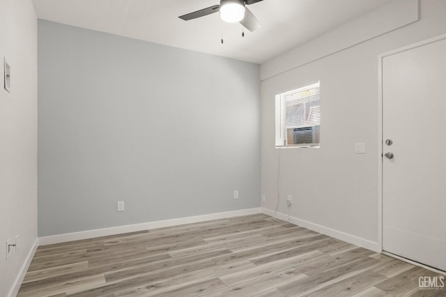 unfurnished room with a ceiling fan, light wood-type flooring, cooling unit, and baseboards