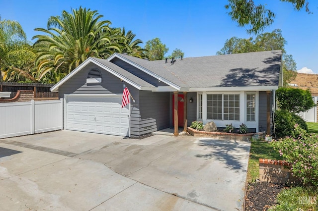 ranch-style house featuring a garage, driveway, and fence