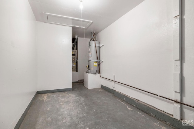 garage featuring strapped water heater and baseboards