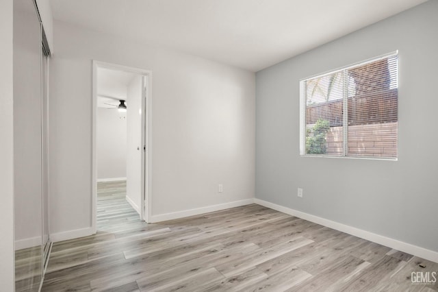 unfurnished room featuring light wood-type flooring and baseboards