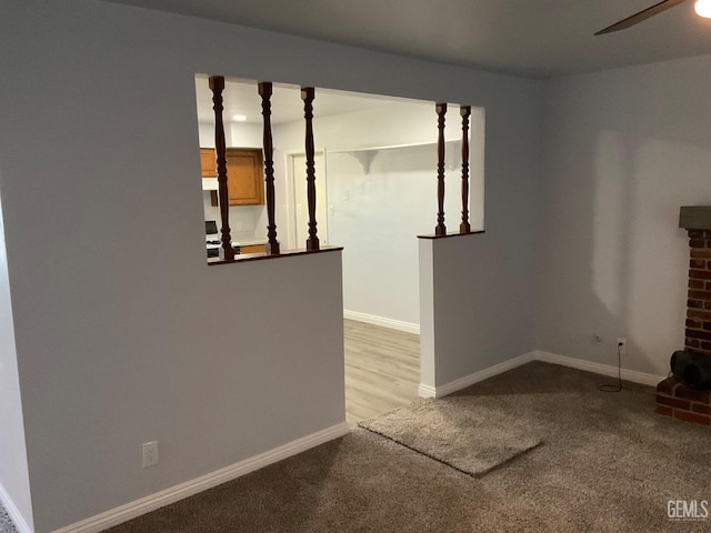 unfurnished living room with light colored carpet and ceiling fan