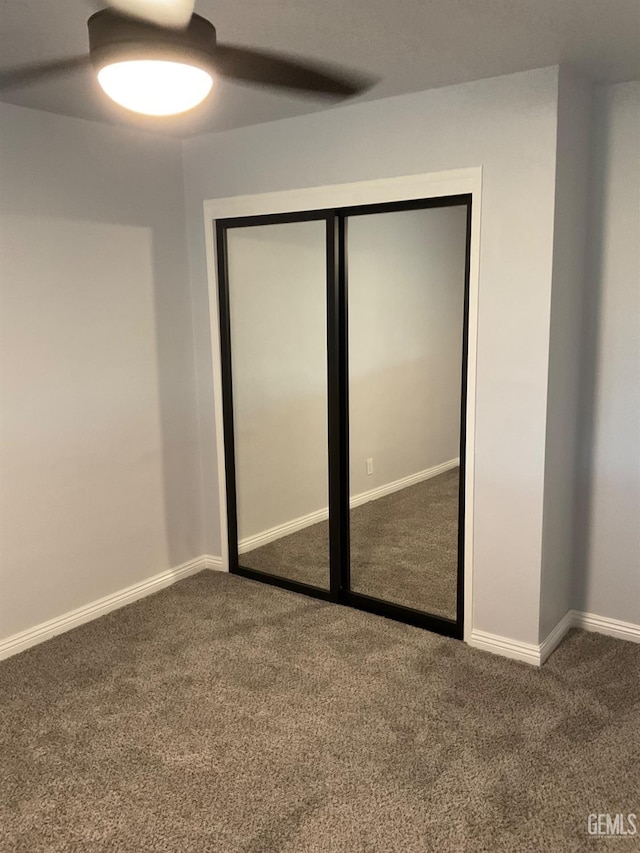 unfurnished bedroom with carpet flooring, ceiling fan, and a closet