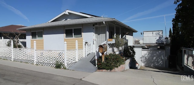 view of front of home featuring an outbuilding and roof with shingles