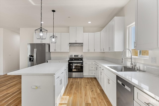30717 Paseo De Pico, Shafter, CA 93263 - kitchen with appliances with stainless steel finishes, under cabinet range hood, a kitchen island, light wood finished floors, and light countertops