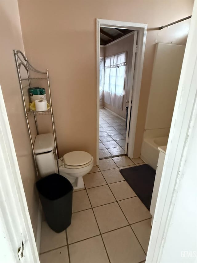 bathroom featuring a bathtub, tile patterned flooring, and toilet