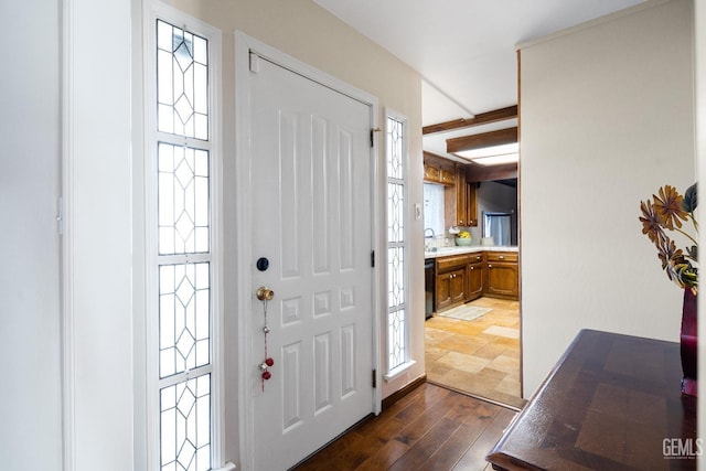 entryway with sink, beamed ceiling, and dark hardwood / wood-style floors