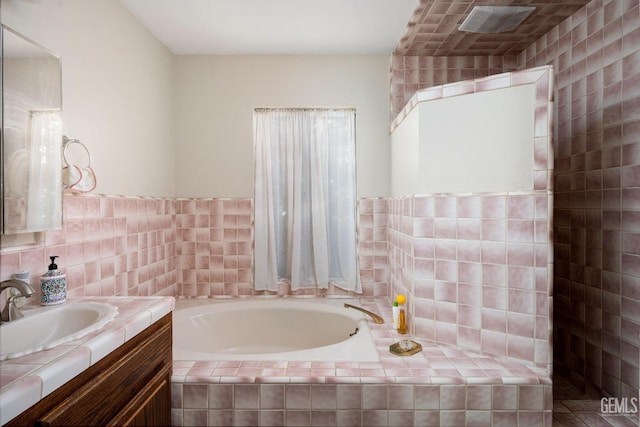 bathroom with a relaxing tiled tub and vanity