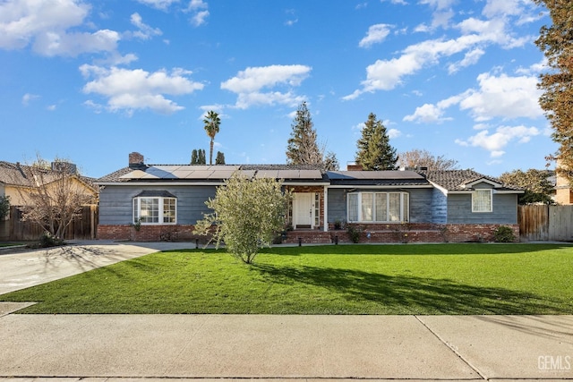 ranch-style home featuring solar panels and a front yard