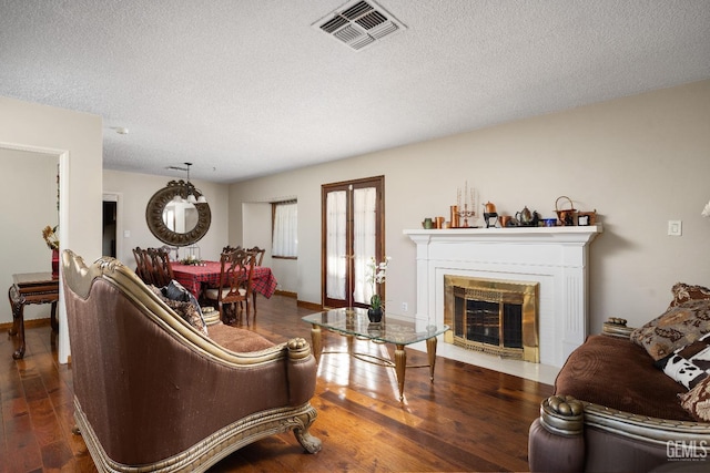 living room featuring a textured ceiling and dark hardwood / wood-style floors