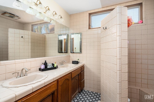 bathroom featuring vanity, tiled shower, tile walls, and backsplash