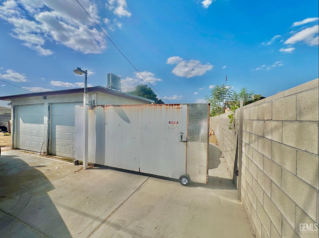 view of property exterior with central AC unit and a garage