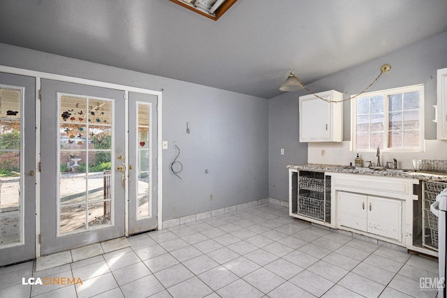 kitchen featuring wine cooler, sink, white cabinetry, light stone counters, and light tile patterned floors