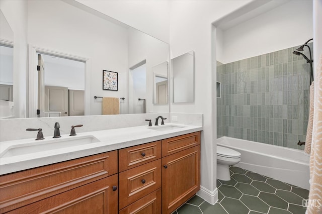 bathroom with tile patterned flooring, a sink, double vanity, and toilet