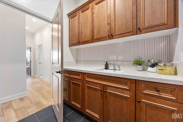 bar featuring baseboards, tile patterned flooring, a sink, and recessed lighting