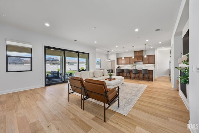 living area with recessed lighting, baseboards, visible vents, and light wood-type flooring