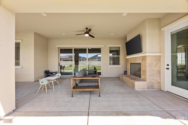view of patio featuring an outdoor living space with a fireplace and a ceiling fan