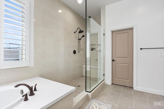 bathroom featuring a tile shower, baseboards, and tile patterned floors