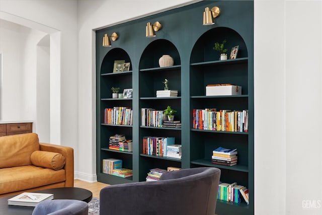 sitting room featuring wood finished floors and built in shelves