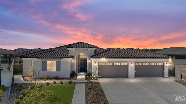 view of front of house featuring stucco siding, concrete driveway, a tiled roof, and a garage