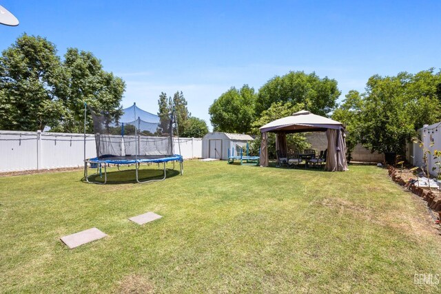 view of yard with a gazebo, a storage unit, and a trampoline