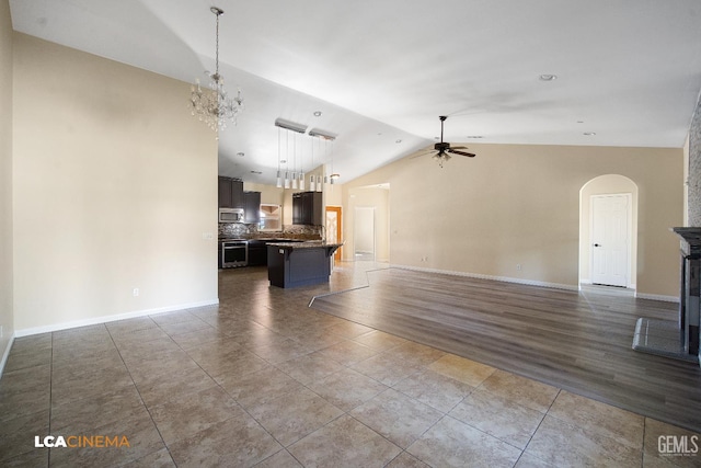 917 Newcastle Ct, Shafter, CA 93263 - unfurnished living room featuring a ceiling fan, arched walkways, lofted ceiling, a chandelier, and baseboards