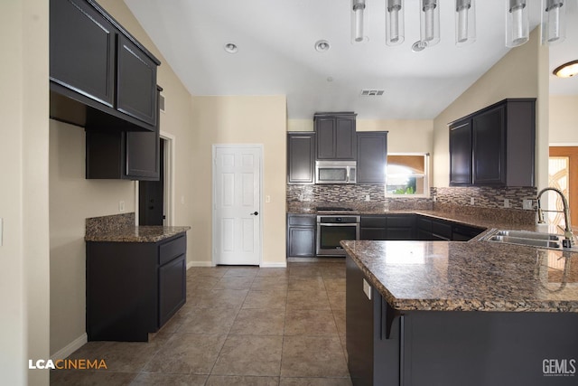 917 Newcastle Ct, Shafter, CA 93263 - kitchen with appliances with stainless steel finishes, a sink, lofted ceiling, decorative backsplash, and baseboards