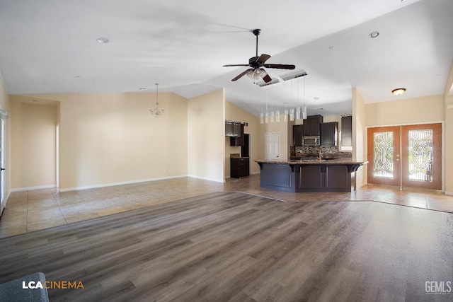 917 Newcastle Ct, Shafter, CA 93263 - unfurnished living room with light wood-style floors, vaulted ceiling, french doors, ceiling fan, and baseboards