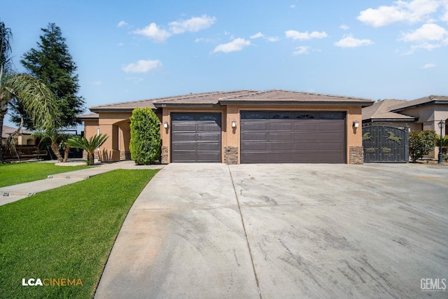 917 Newcastle Ct, Shafter, CA 93263 - prairie-style home with concrete driveway, stucco siding, an attached garage, a front yard, and stone siding