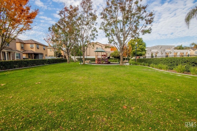 view of yard with a residential view, fence, and playground community