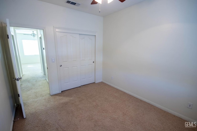 unfurnished bedroom featuring carpet, a closet, visible vents, ceiling fan, and baseboards