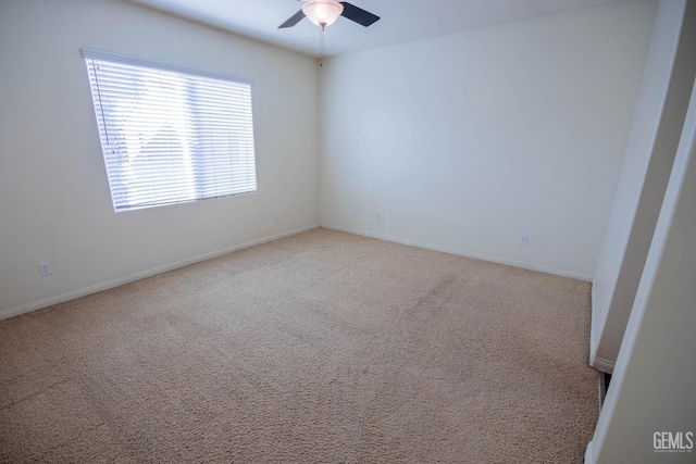 unfurnished room featuring light carpet, ceiling fan, and baseboards