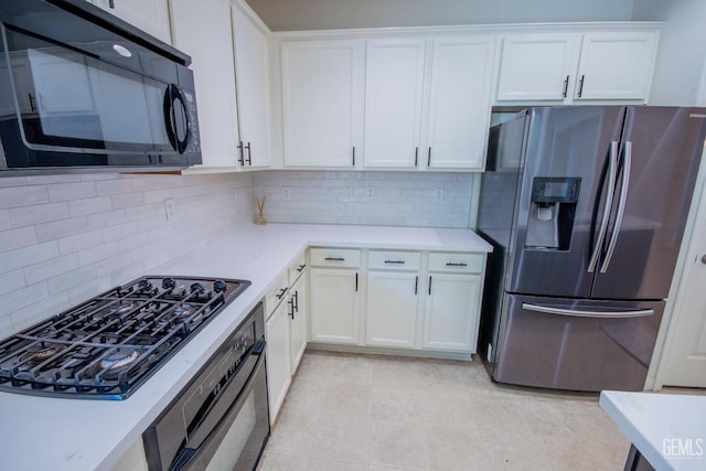 kitchen with stainless steel appliances, white cabinets, and tasteful backsplash