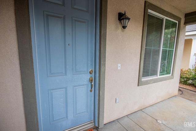 view of exterior entry with stucco siding