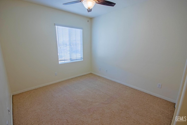 spare room featuring baseboards, ceiling fan, and light colored carpet