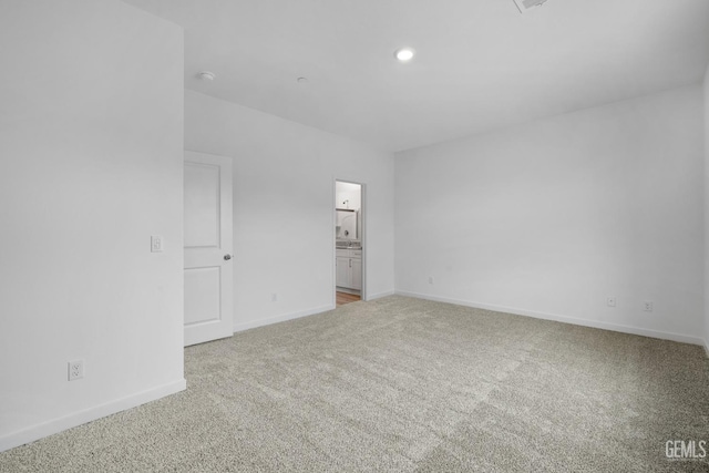 unfurnished bedroom with ensuite bathroom, carpet floors, recessed lighting, and baseboards