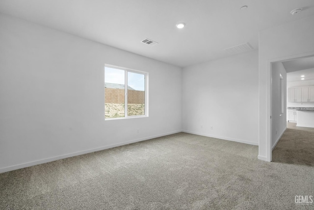 carpeted spare room with recessed lighting, visible vents, and baseboards