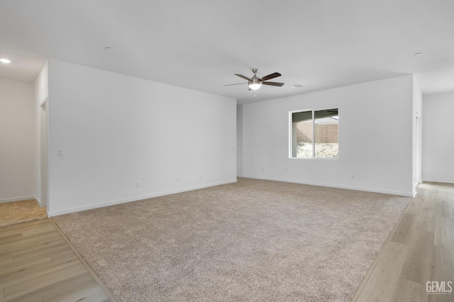 unfurnished room with light wood-type flooring, ceiling fan, and baseboards