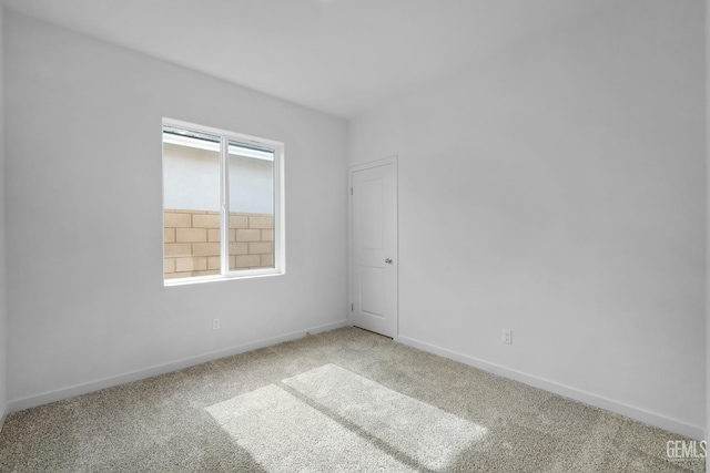 unfurnished room with carpet and baseboards