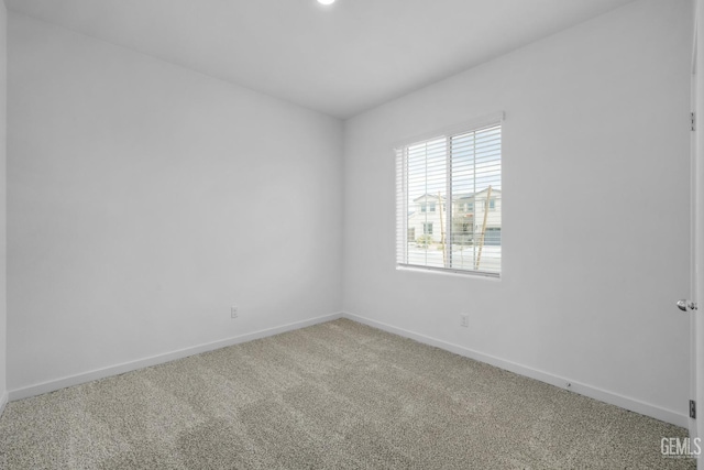 spare room featuring carpet flooring and baseboards