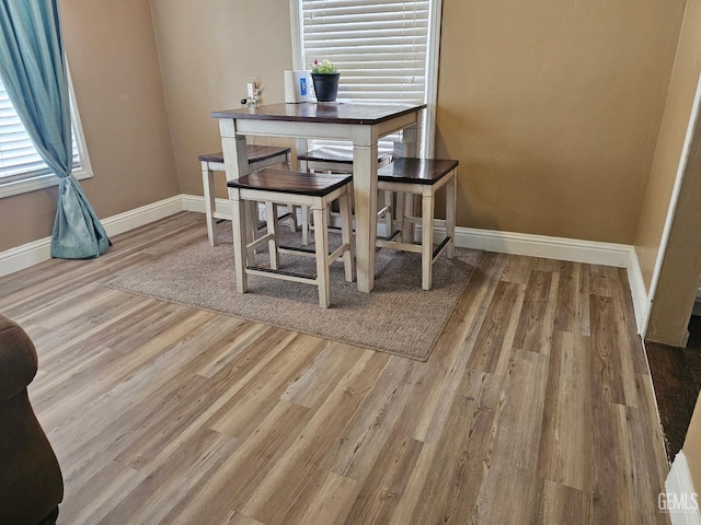 dining area with a wealth of natural light and light hardwood / wood-style flooring