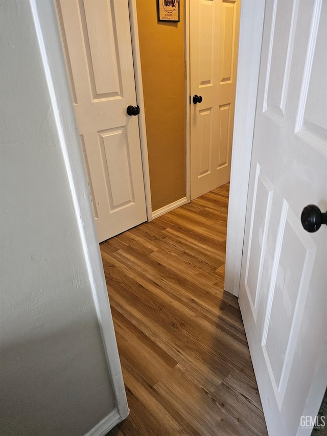 hallway with dark hardwood / wood-style flooring