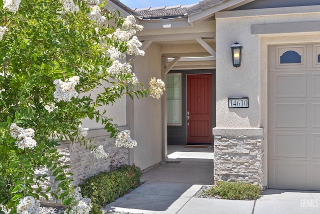14610 Coyle Cir, Bakersfield, CA 93311 - property entrance with stucco siding, stone siding, and a garage