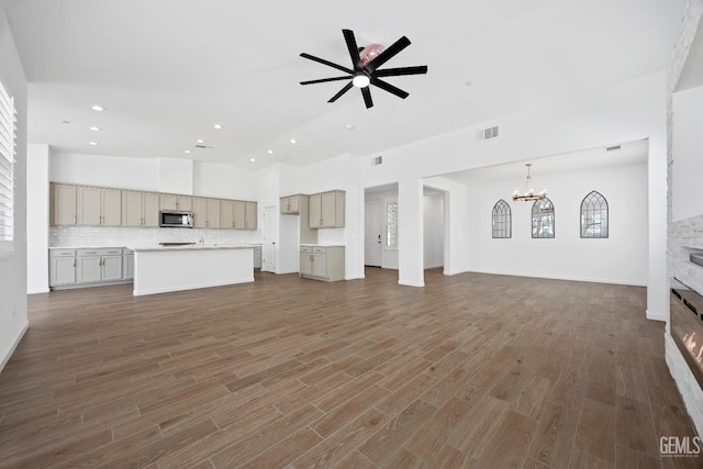 14610 Coyle Cir, Bakersfield, CA 93311 - unfurnished living room with recessed lighting, a chandelier, a stone fireplace, ceiling fan, and wood finished floors