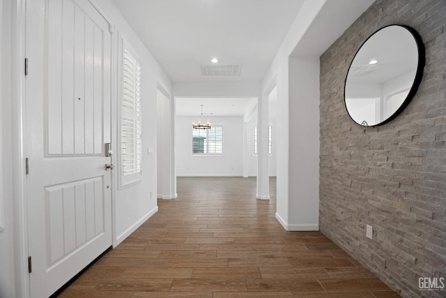 14610 Coyle Cir, Bakersfield, CA 93311 - corridor with a chandelier, brick wall, wood finished floors, and recessed lighting
