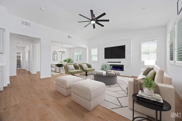 14610 Coyle Cir, Bakersfield, CA 93311 - living room featuring light wood finished floors, a large fireplace, ceiling fan, vaulted ceiling, and plenty of natural light