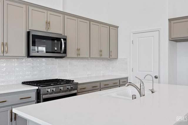 14610 Coyle Cir, Bakersfield, CA 93311 - kitchen with stainless steel appliances, gray cabinets, light countertops, and backsplash